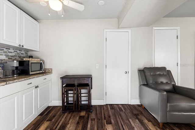 living area with dark hardwood / wood-style floors and ceiling fan