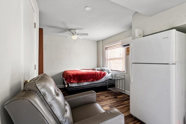 bedroom with dark hardwood / wood-style floors, white refrigerator, an AC wall unit, and ceiling fan