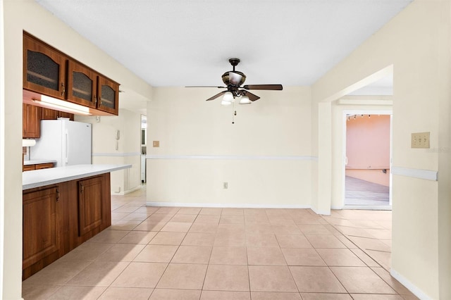 kitchen with ceiling fan, light tile patterned floors, and white refrigerator