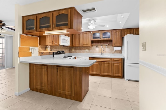 kitchen featuring sink, backsplash, kitchen peninsula, white appliances, and light tile patterned flooring