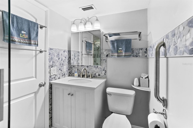 bathroom featuring vanity, toilet, and backsplash