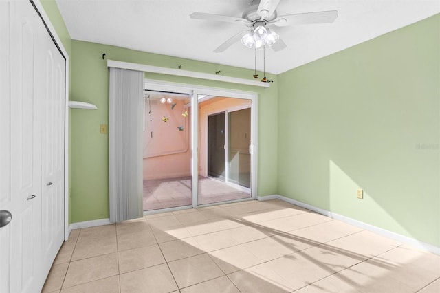 tiled empty room featuring ceiling fan