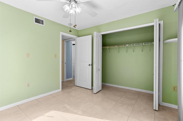 unfurnished bedroom with light tile patterned floors, a closet, and ceiling fan