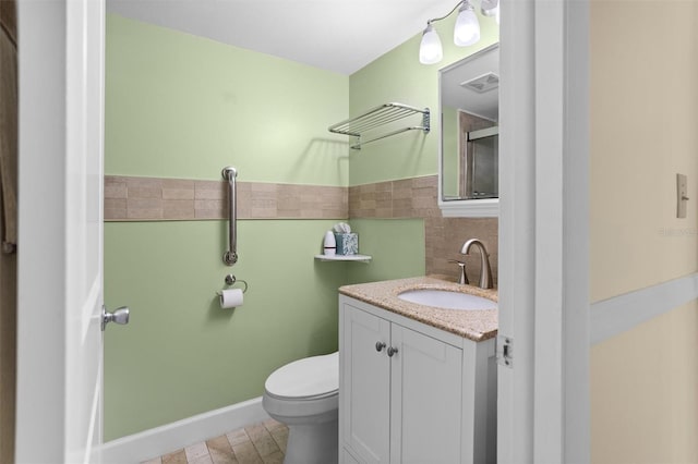 bathroom with vanity, toilet, and backsplash