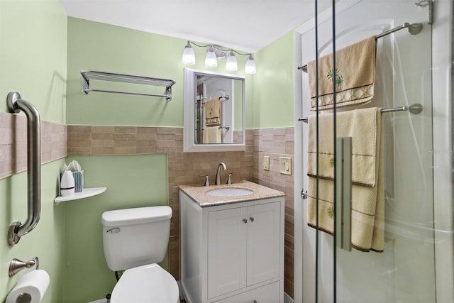 bathroom featuring vanity, toilet, and tile walls