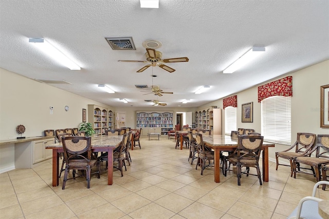 tiled dining area featuring ceiling fan and a textured ceiling