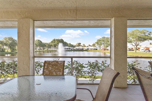 sunroom featuring a water view and a wealth of natural light