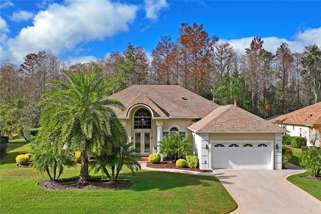 view of front of home with a front lawn, a garage, and french doors