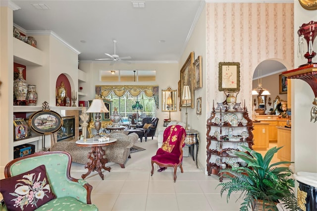 living room featuring ceiling fan, built in features, light tile patterned floors, and crown molding