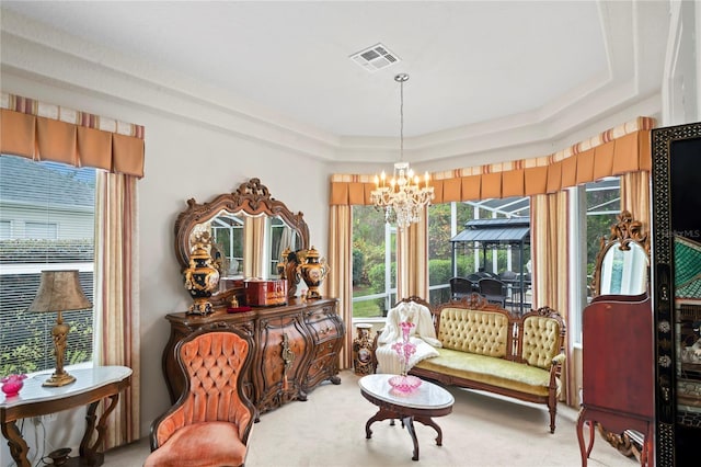 sitting room with carpet flooring, a raised ceiling, and a chandelier