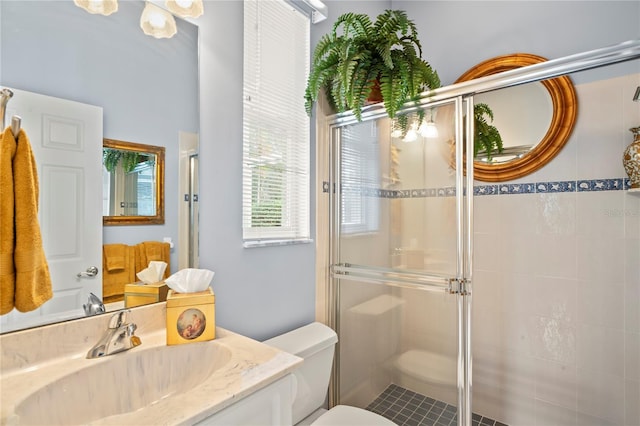 bathroom with vanity, toilet, and a shower with shower door