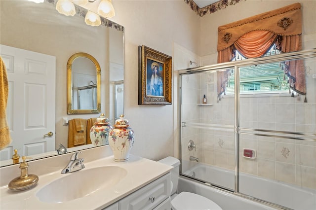 full bathroom with vanity, toilet, and bath / shower combo with glass door