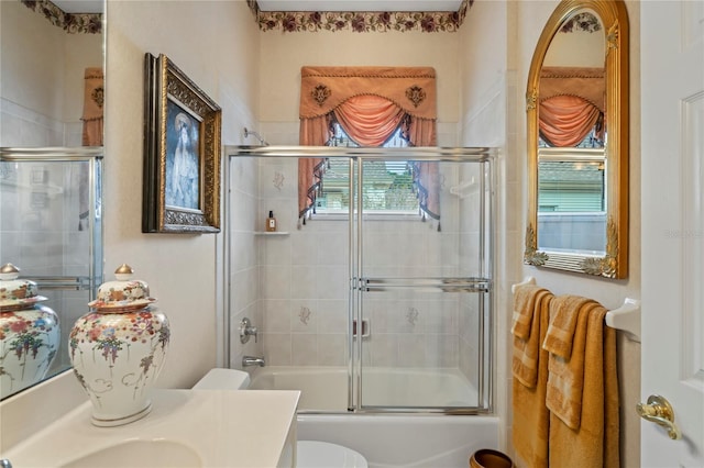 full bathroom with toilet, vanity, and combined bath / shower with glass door