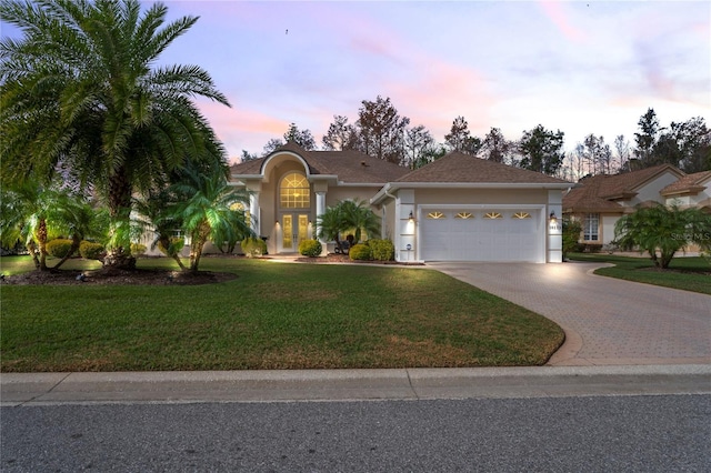 view of front facade featuring a lawn and a garage