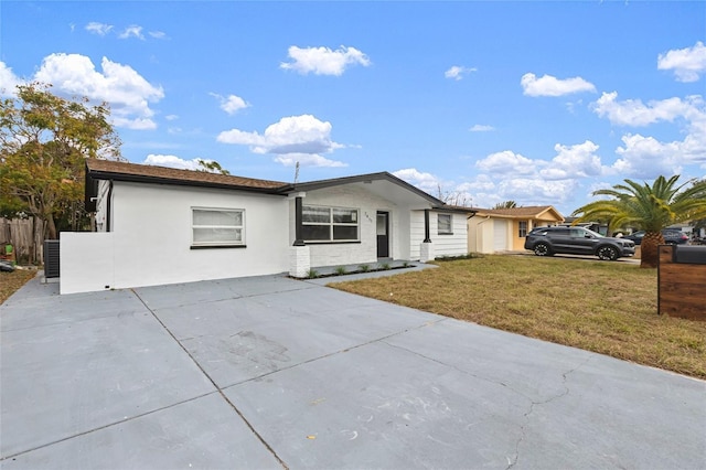 single story home featuring cooling unit and a front yard