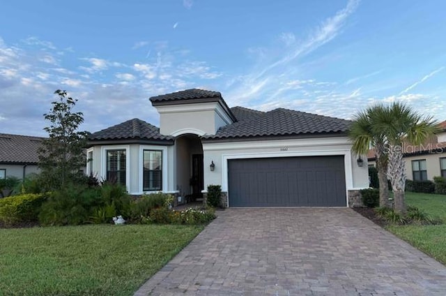 mediterranean / spanish house featuring a garage and a front lawn