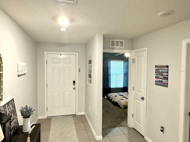 tiled foyer entrance featuring a textured ceiling