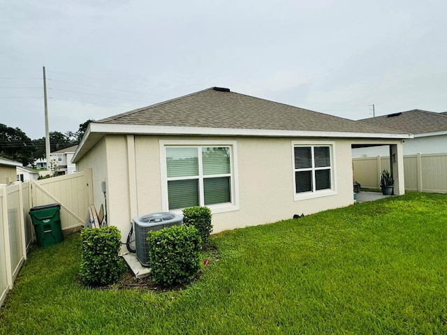 view of side of home with a yard and cooling unit