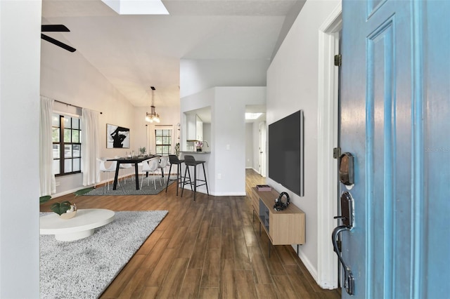 entryway with dark hardwood / wood-style floors, ceiling fan with notable chandelier, and vaulted ceiling