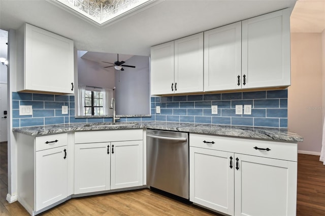 kitchen with white cabinets, light hardwood / wood-style floors, and stainless steel dishwasher