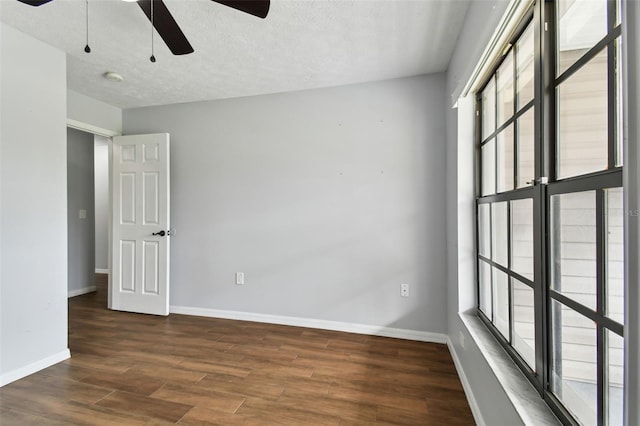 unfurnished room with a textured ceiling, ceiling fan, and dark wood-type flooring