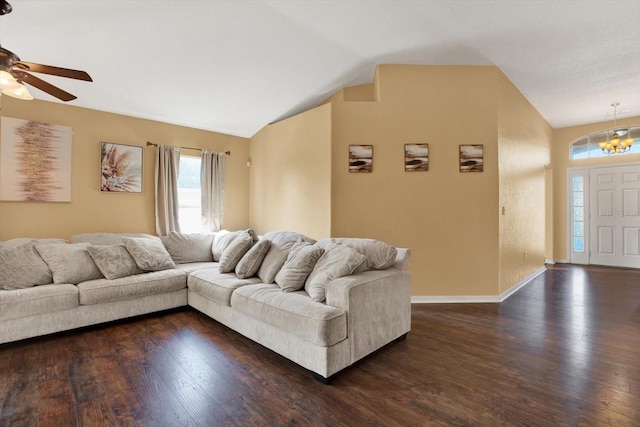 living room with ceiling fan with notable chandelier, dark hardwood / wood-style flooring, and lofted ceiling