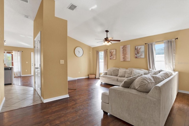 living room featuring dark wood-type flooring, a wealth of natural light, and vaulted ceiling