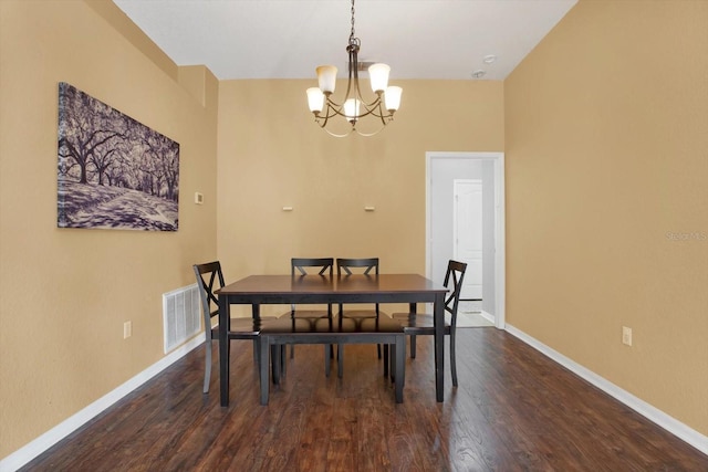 dining room with dark hardwood / wood-style flooring and a notable chandelier