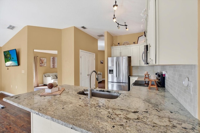 kitchen featuring light stone countertops, sink, tasteful backsplash, white cabinets, and appliances with stainless steel finishes