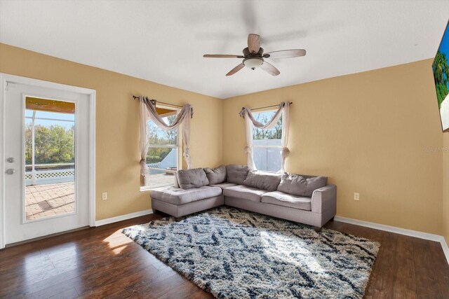 living room with ceiling fan and dark wood-type flooring