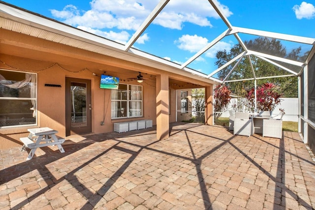 view of patio featuring glass enclosure and ceiling fan