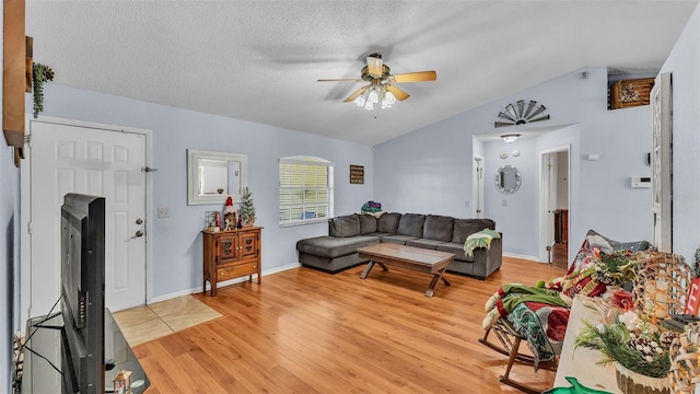 living room featuring light hardwood / wood-style floors, a textured ceiling, ceiling fan, and vaulted ceiling