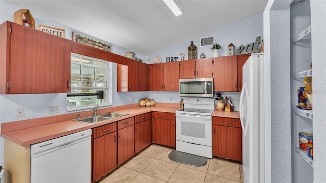 kitchen with white appliances, a textured ceiling, vaulted ceiling, light tile patterned flooring, and sink