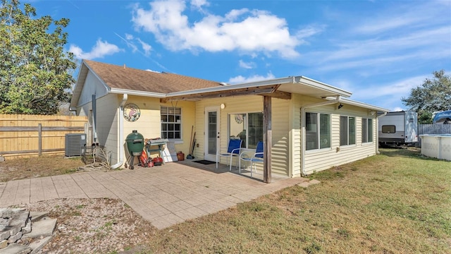 back of property with central air condition unit, a patio, and a yard