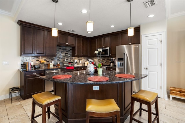 kitchen featuring tasteful backsplash, ornamental molding, stainless steel appliances, a center island, and hanging light fixtures