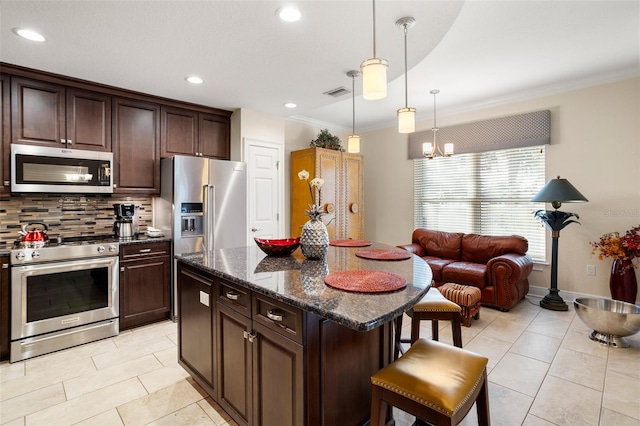 kitchen with backsplash, dark stone counters, dark brown cabinets, high end appliances, and pendant lighting