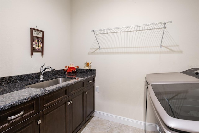 clothes washing area with cabinets, light tile patterned floors, separate washer and dryer, and sink