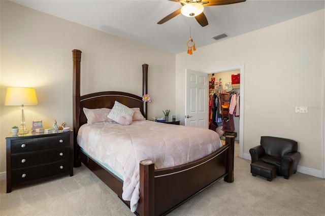 carpeted bedroom featuring a walk in closet, a closet, and ceiling fan