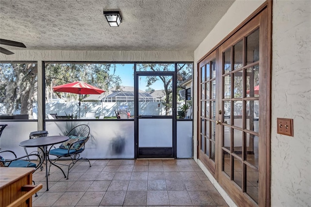 unfurnished sunroom with ceiling fan