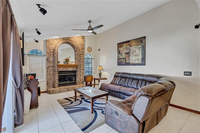 tiled living room featuring ceiling fan, lofted ceiling, and a fireplace