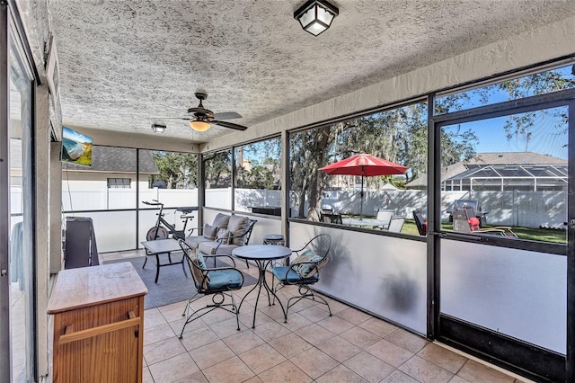 unfurnished sunroom featuring ceiling fan