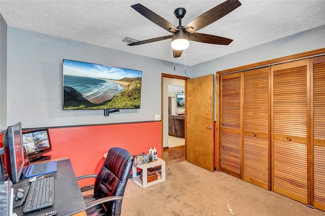 office space featuring ceiling fan, a textured ceiling, and light carpet