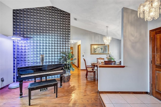 entrance foyer featuring vaulted ceiling, light wood-type flooring, and a chandelier