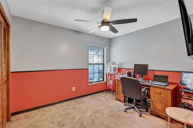 carpeted office featuring ceiling fan and a textured ceiling