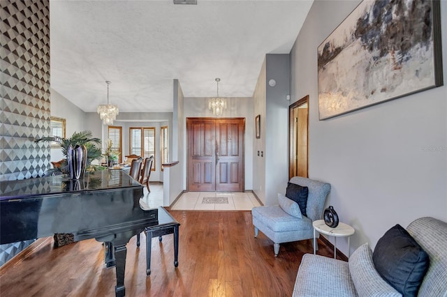 entryway featuring wood-type flooring, vaulted ceiling, and a notable chandelier