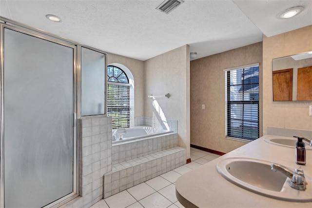 bathroom featuring a textured ceiling, vanity, shower with separate bathtub, and tile patterned floors