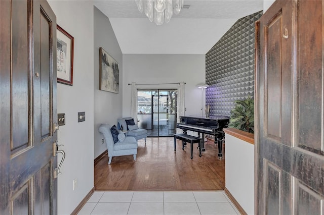 tiled foyer with a textured ceiling and vaulted ceiling