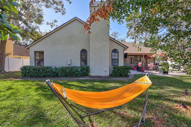 back of property featuring a patio area and a yard