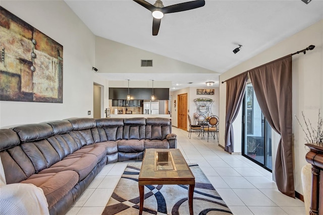 living room featuring ceiling fan, light tile patterned floors, and vaulted ceiling