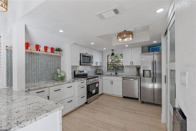 kitchen with sink, light wood-type flooring, white cabinetry, and stainless steel appliances